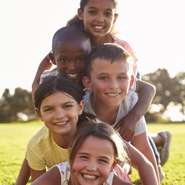 Five Kids Lying in a Pile on the Grass