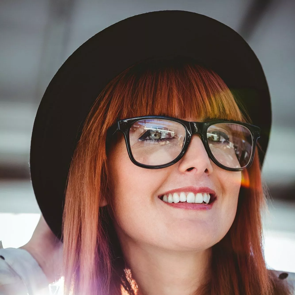 A Young Lady Wearing  A Black Hat and Eyeglasses